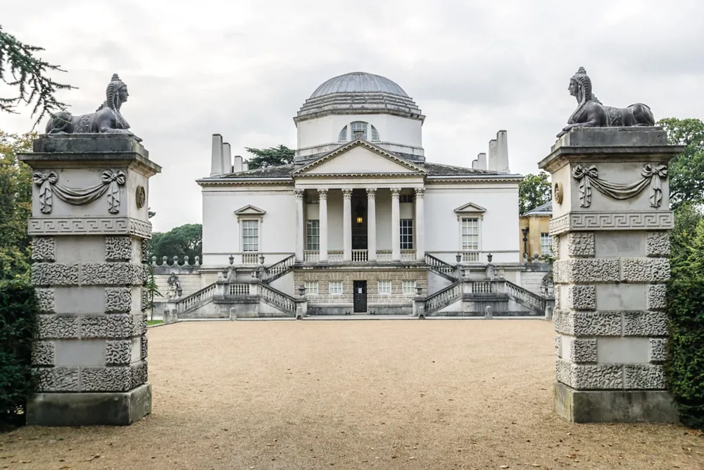 A photo of a white building through ornate gates