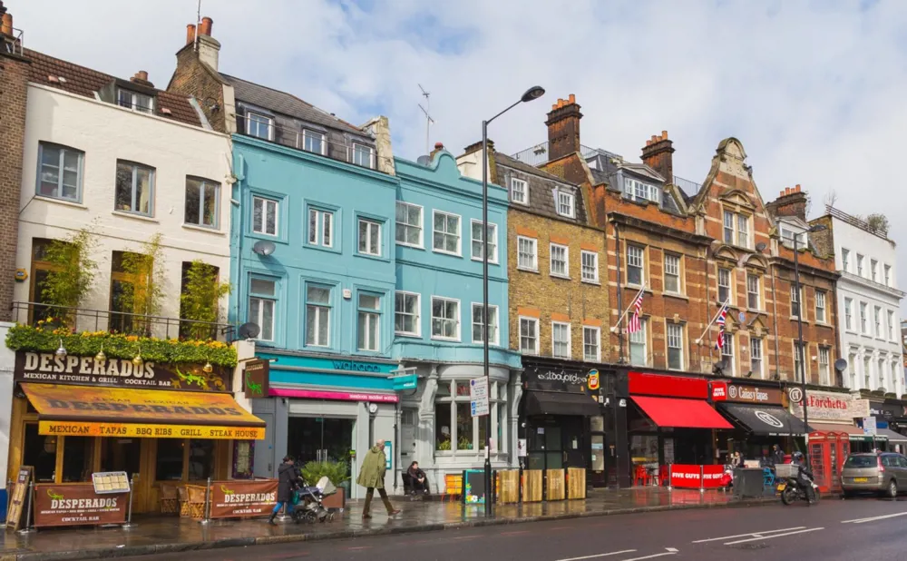 A photo of colourful buildings on one side of a street