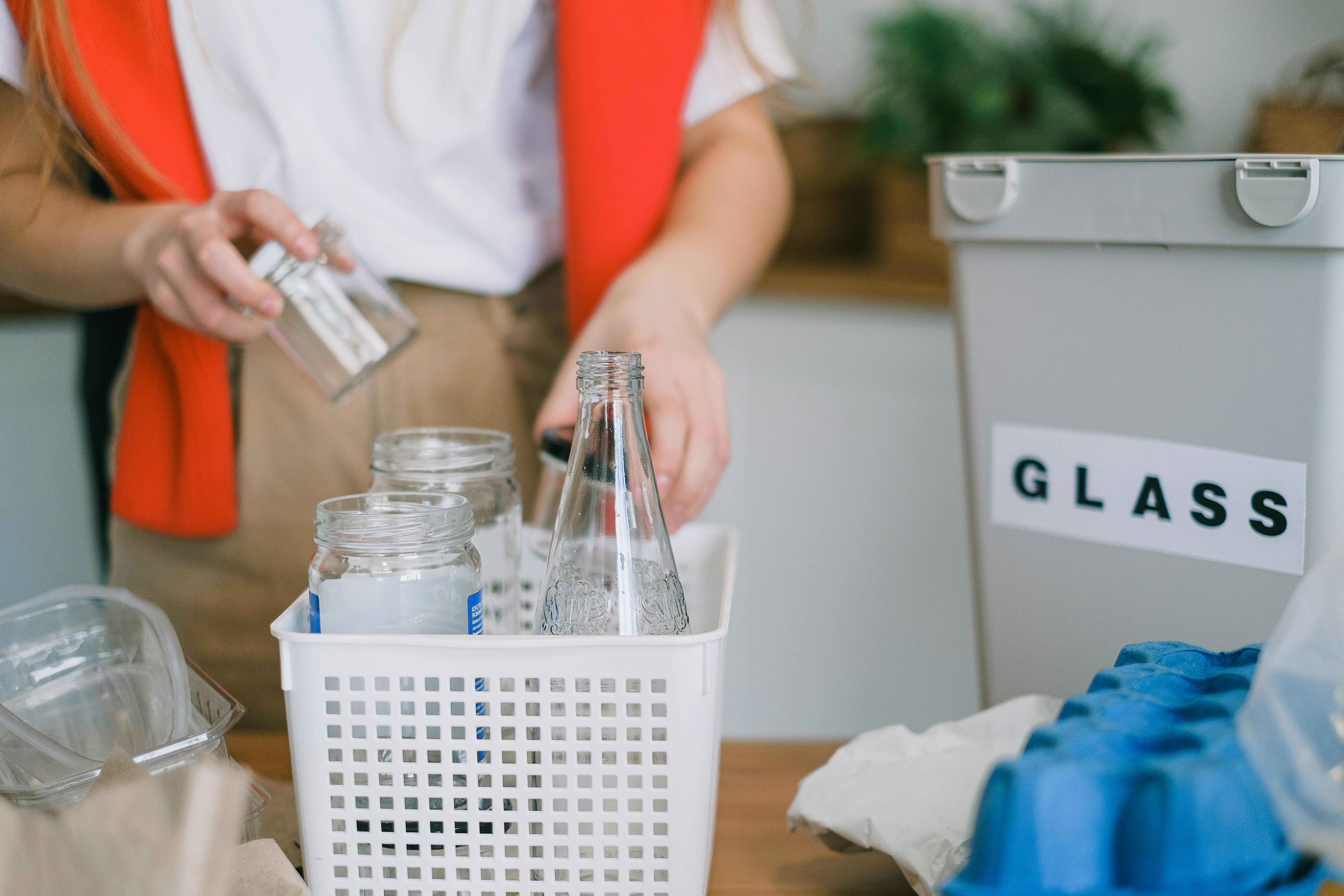 woman sorting glass into glass recycle bin