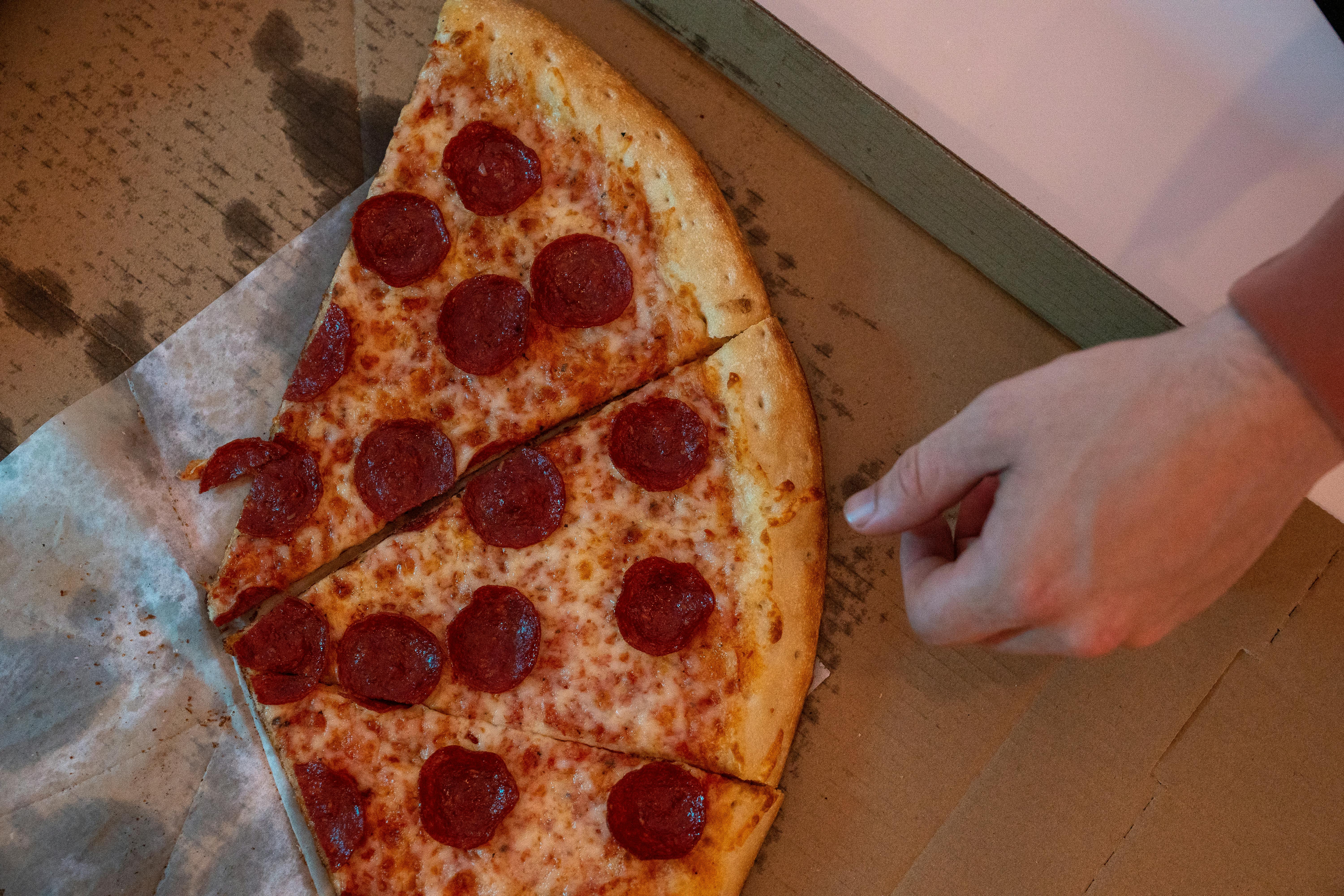 pepperoni pizza on a greasy box